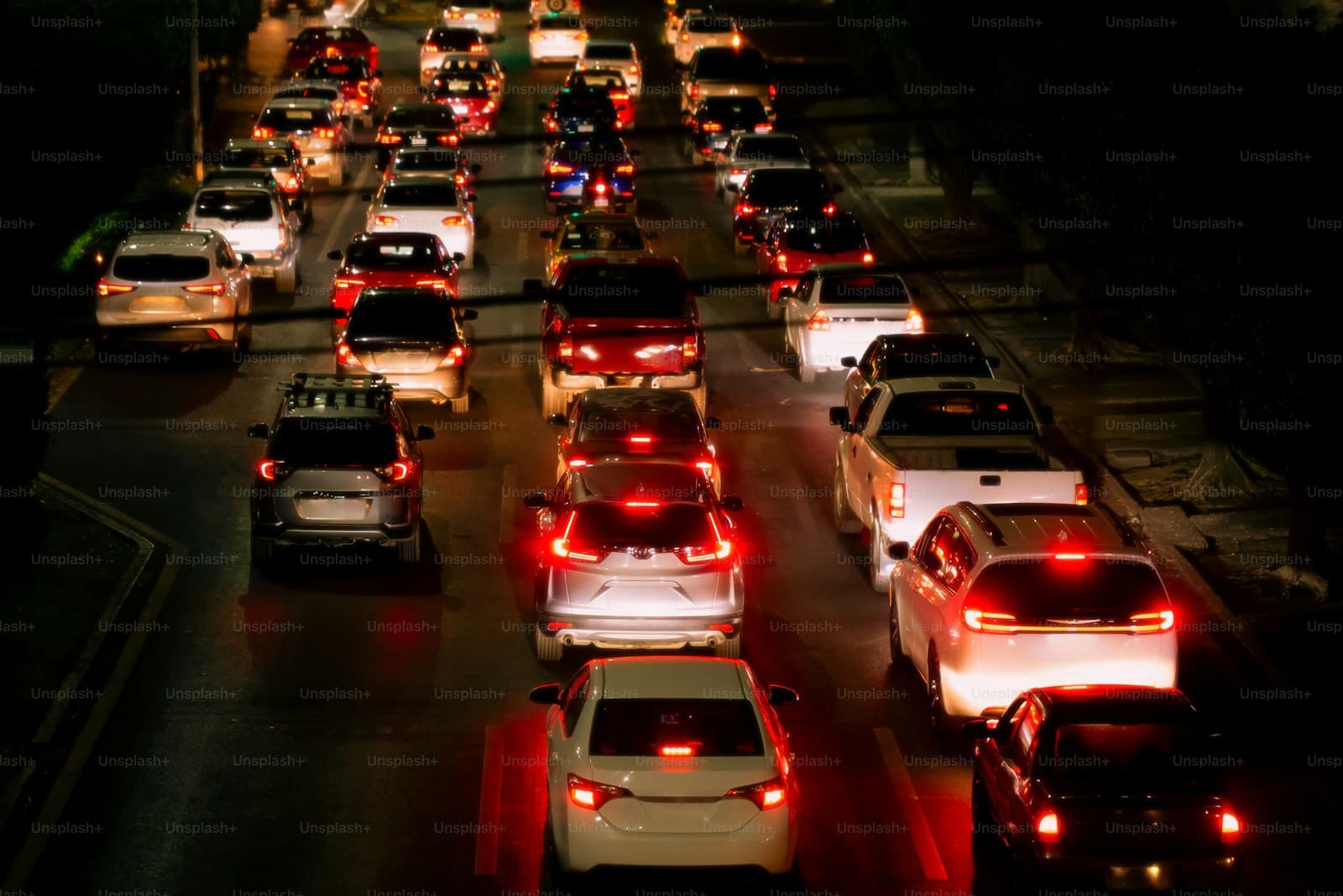 Nighttime traffic jam with rows of cars showing red brake lights and headlights on a busy highway