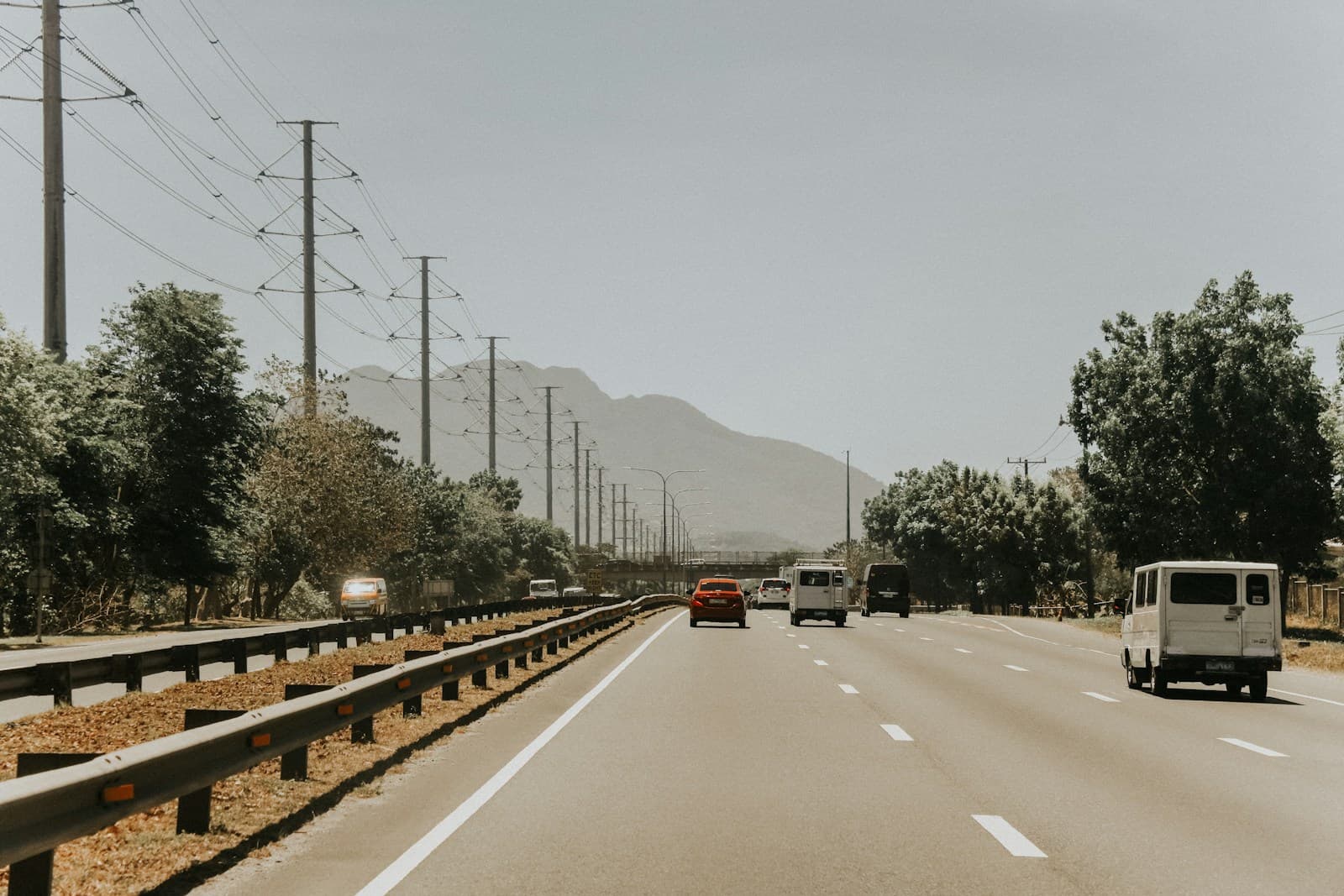 Multi-lane desert highway carrying cars and a white motorhome in both directions